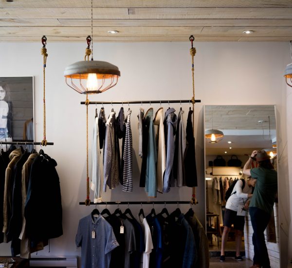 person leaning on wall while holding gray hat